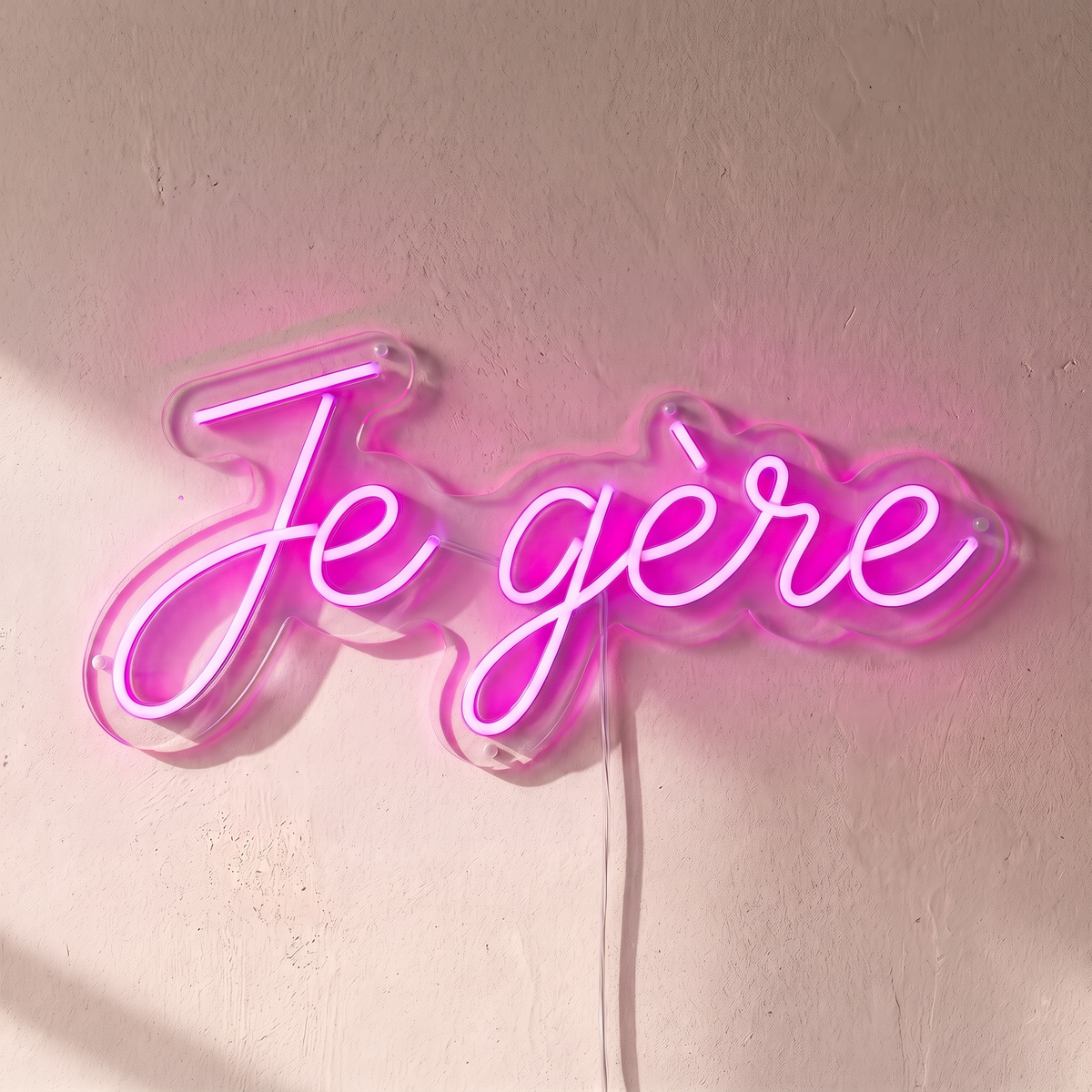 Néon mural « Je gère » rose, gros plan sur fond beige