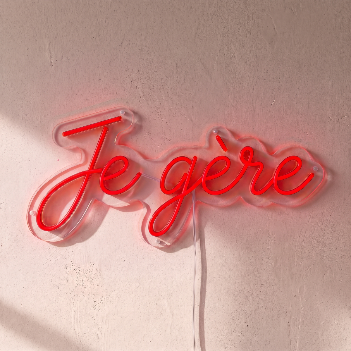 Néon mural « Je gère » rouge, gros plan sur fond beige