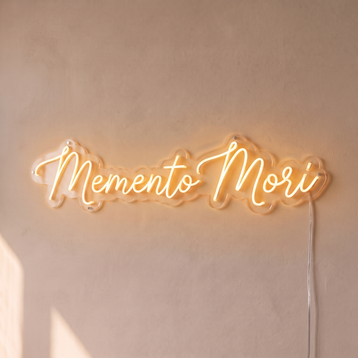 Néon mural « Memento Mori » blanc chaud, gros plan sur fond beige