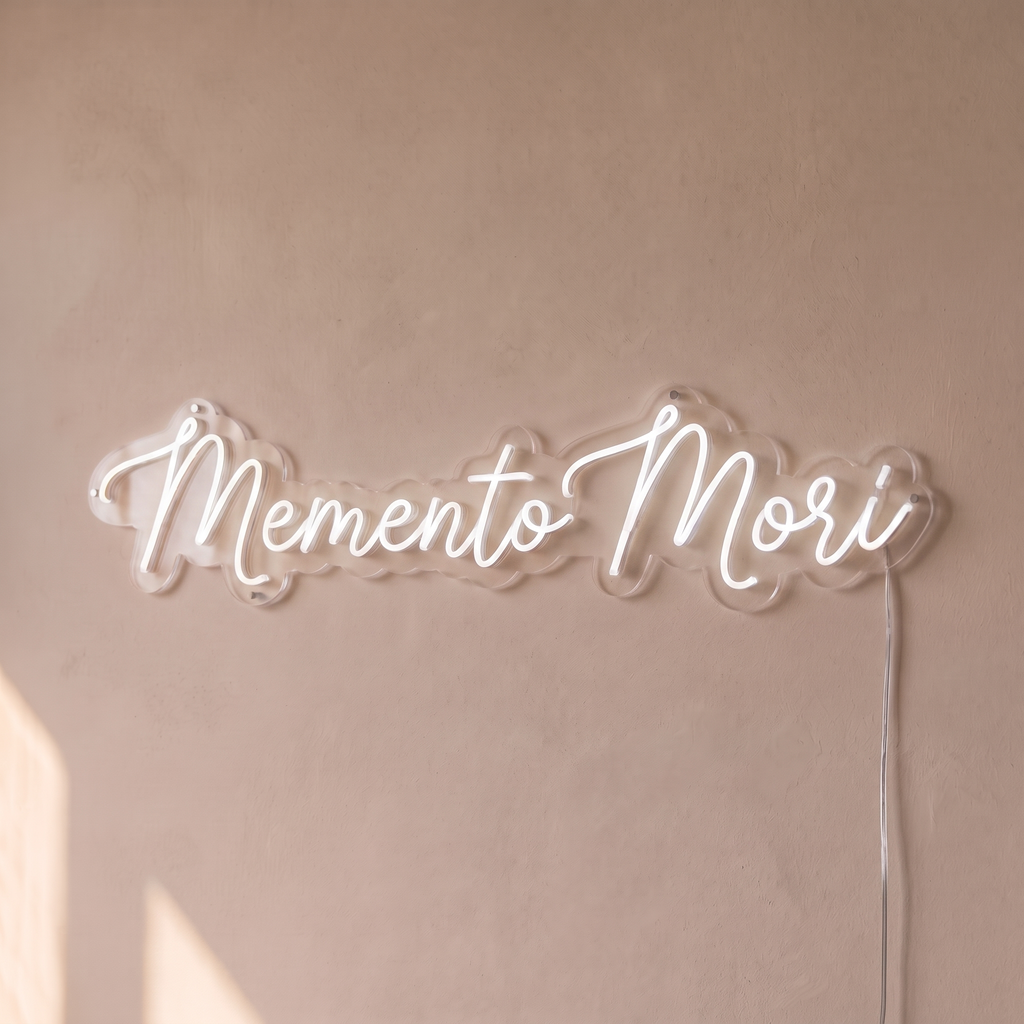 Néon mural « Memento Mori » blanc, gros plan sur fond beige