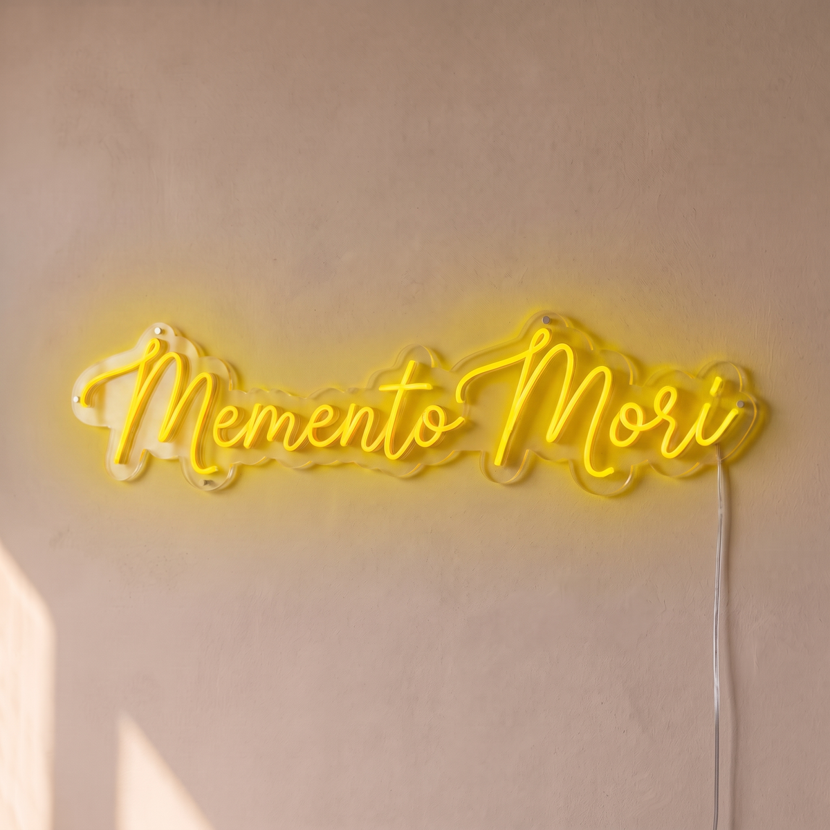 Néon mural « Memento Mori » jaune, gros plan sur fond beige