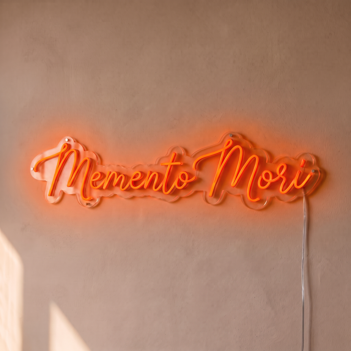 Néon mural « Memento Mori » orange, gros plan sur fond beige