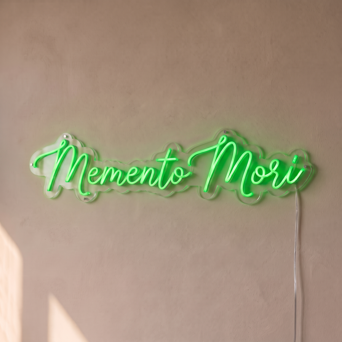Néon mural « Memento Mori » vert, gros plan sur fond beige