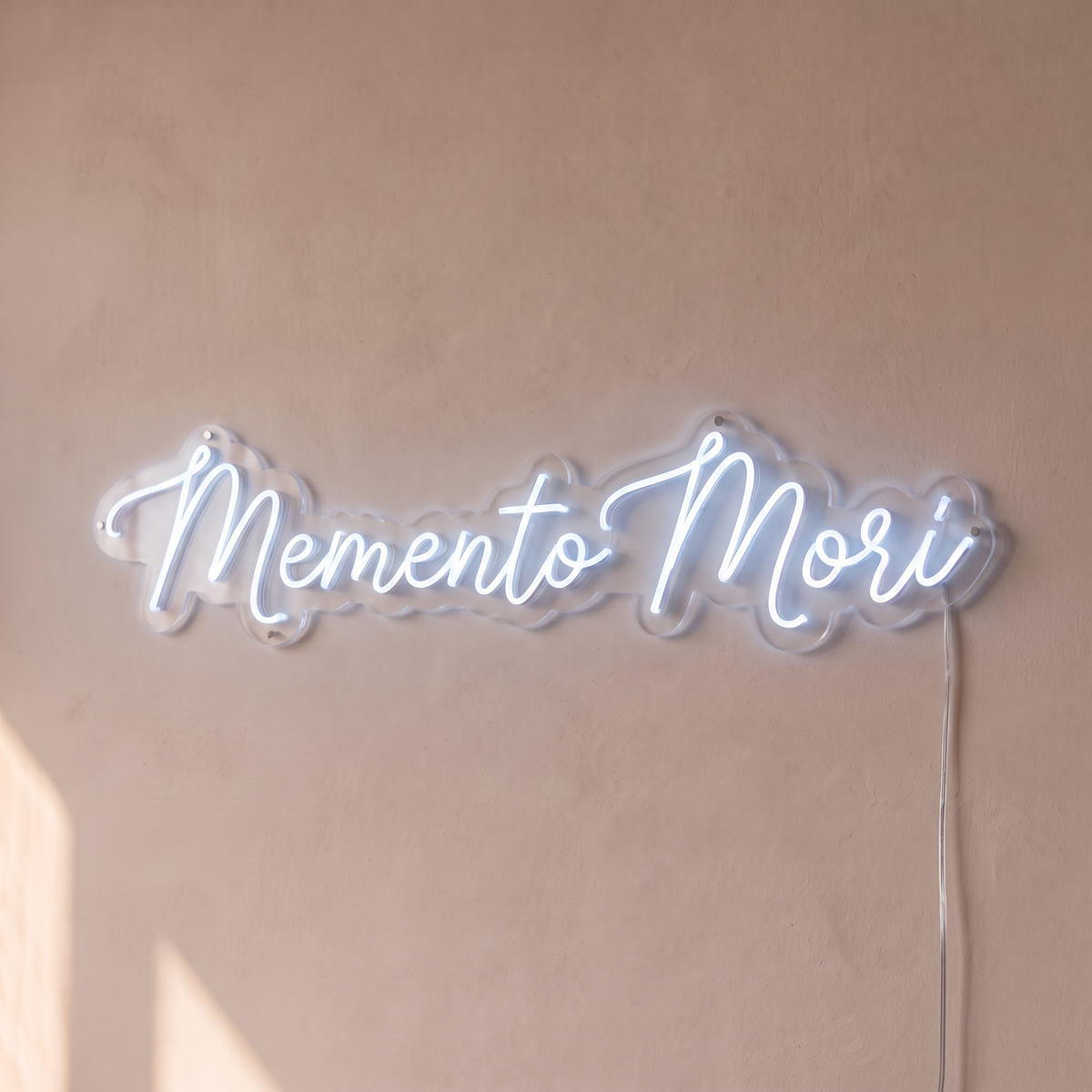 Néon mural « Memento Mori » blanc froid, gros plan sur fond beige