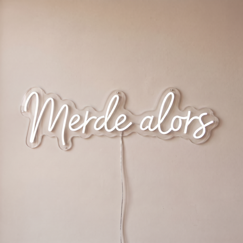 Néon mural « Merde alors » blanc, gros plan sur fond beige