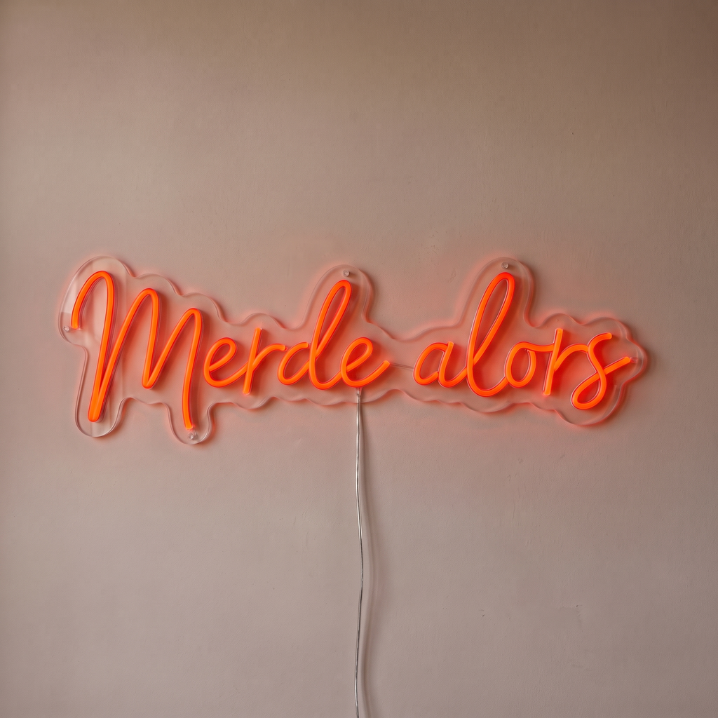 Néon mural « Merde alors » rouge orangé, gros plan sur fond beige