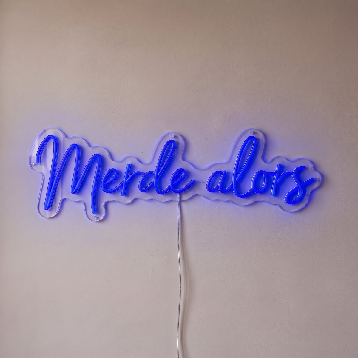 Néon mural « Merde alors » bleu, gros plan sur fond beige