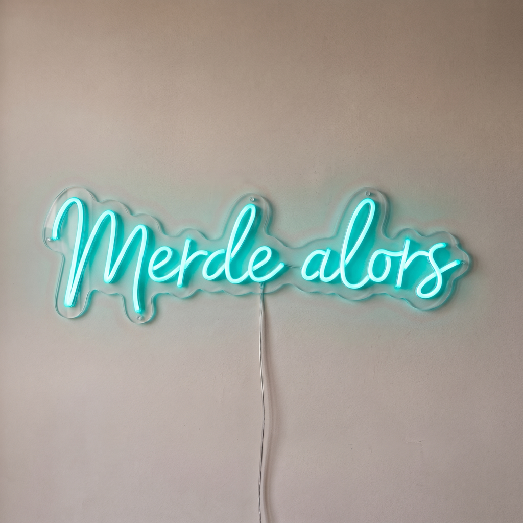 Néon mural « Merde alors » turquoise, gros plan sur fond beige