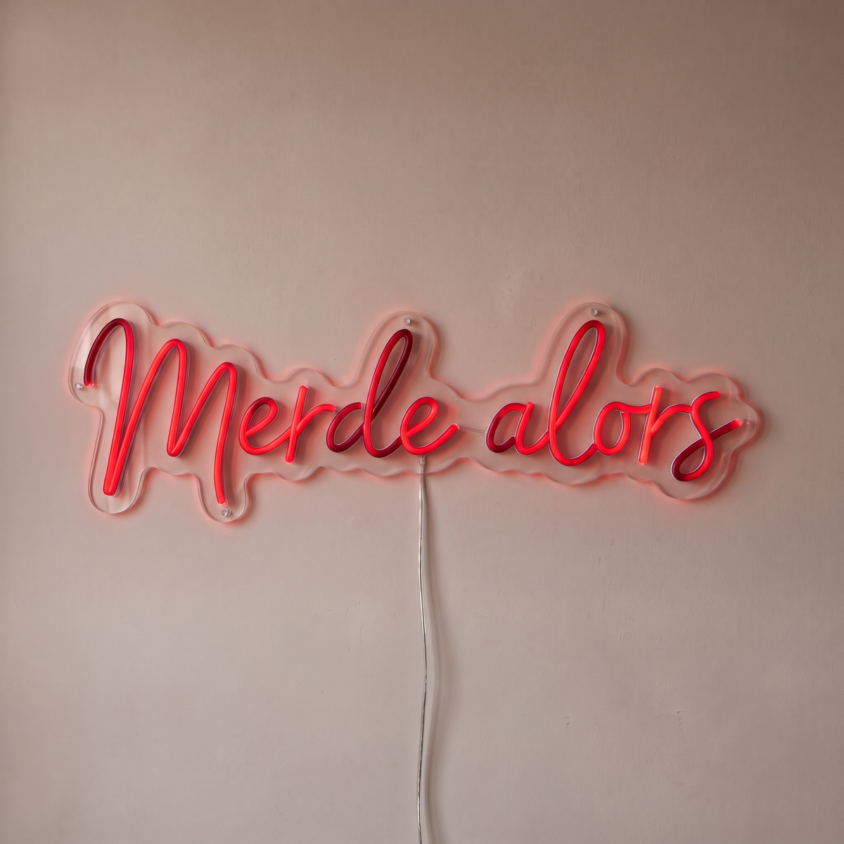 Néon mural « Merde alors » rouge, gros plan sur fond beige