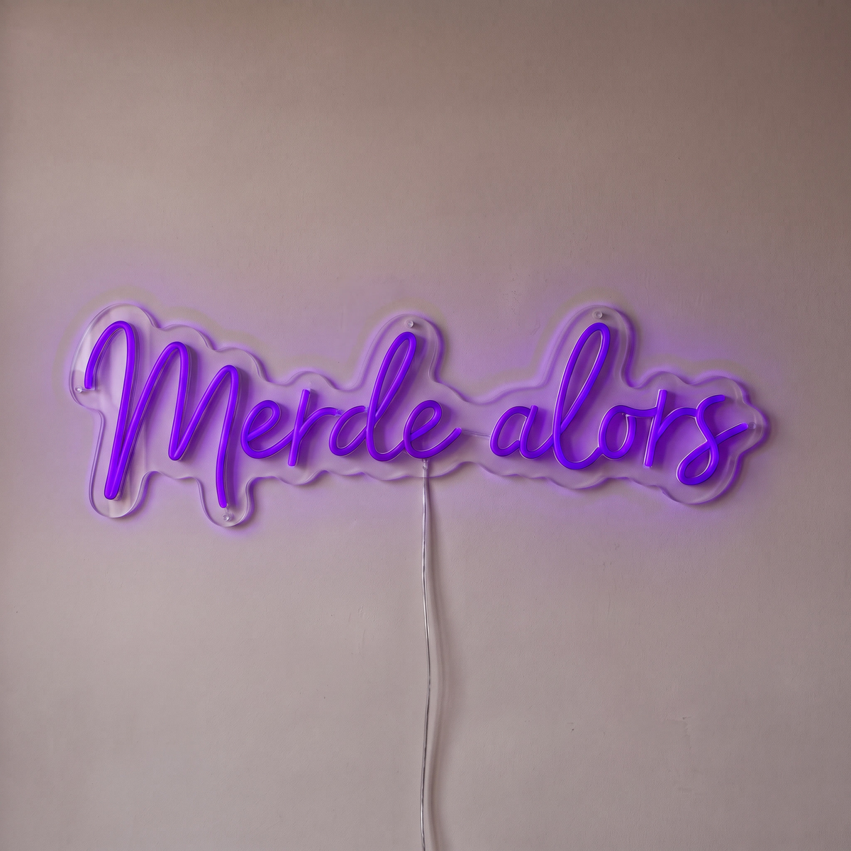 Néon mural « Merde alors » violet, gros plan sur fond beige