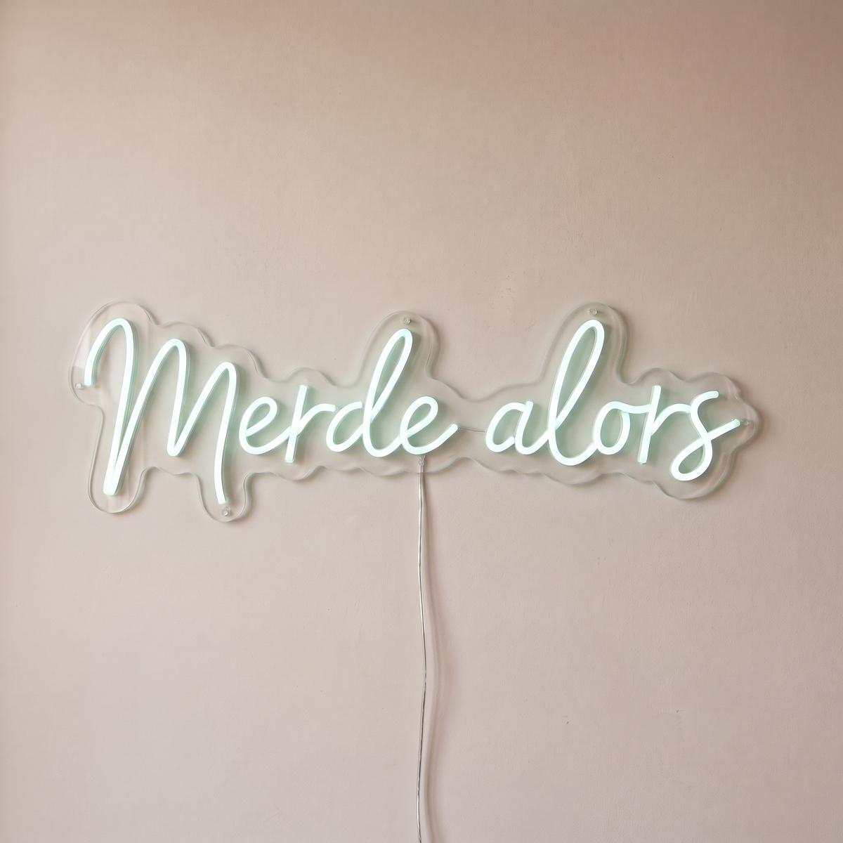 Néon mural « Merde alors » blanc froid, gros plan sur fond beige