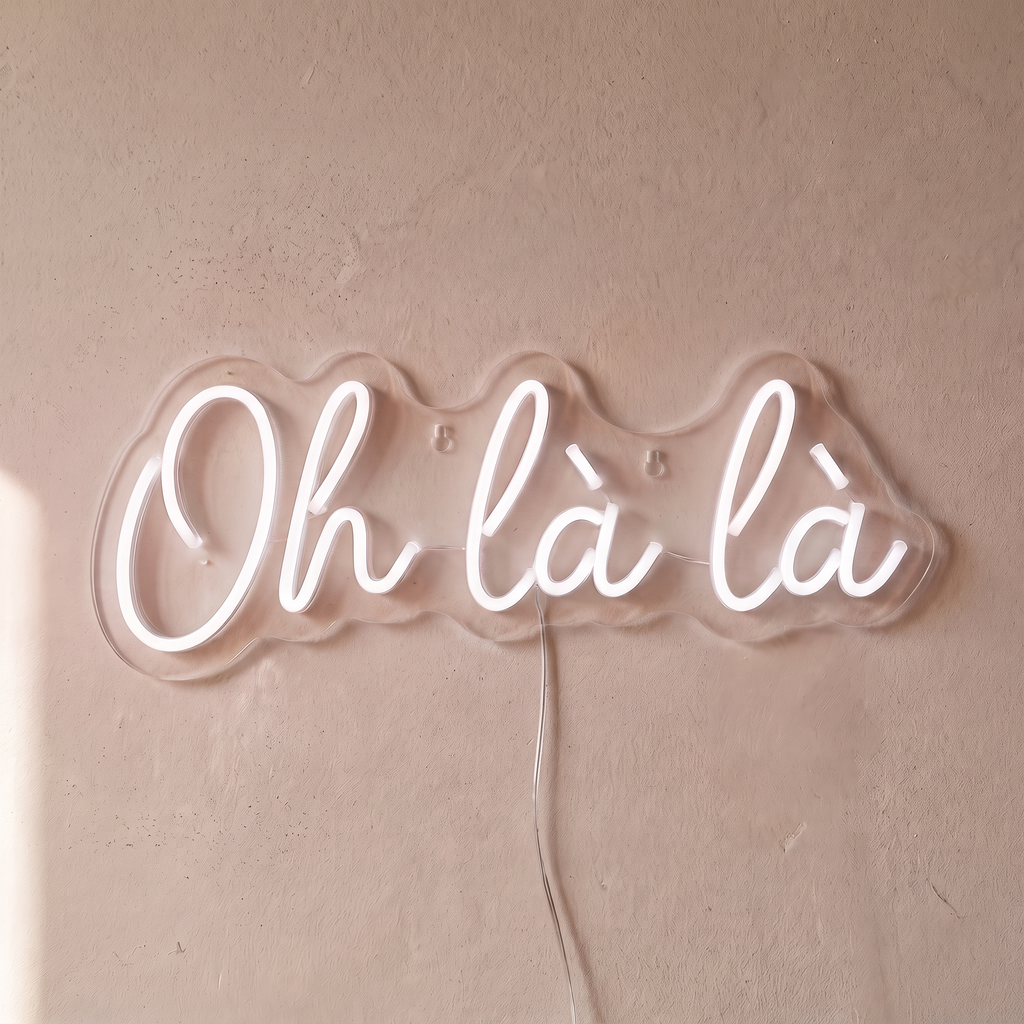 Néon mural « Oh là là » blanc, gros plan sur fond beige