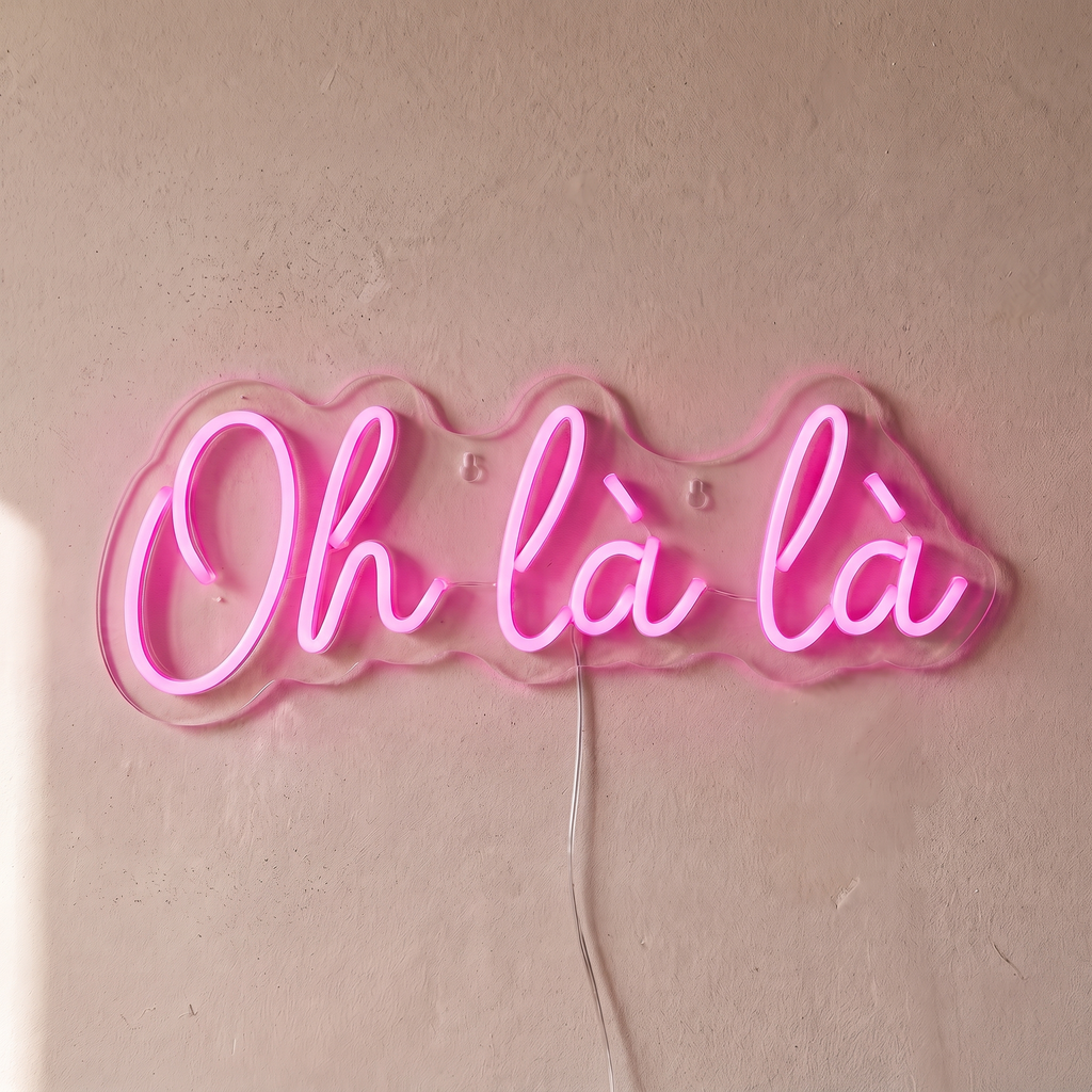 Néon mural « Oh là là » rose, gros plan sur fond beige