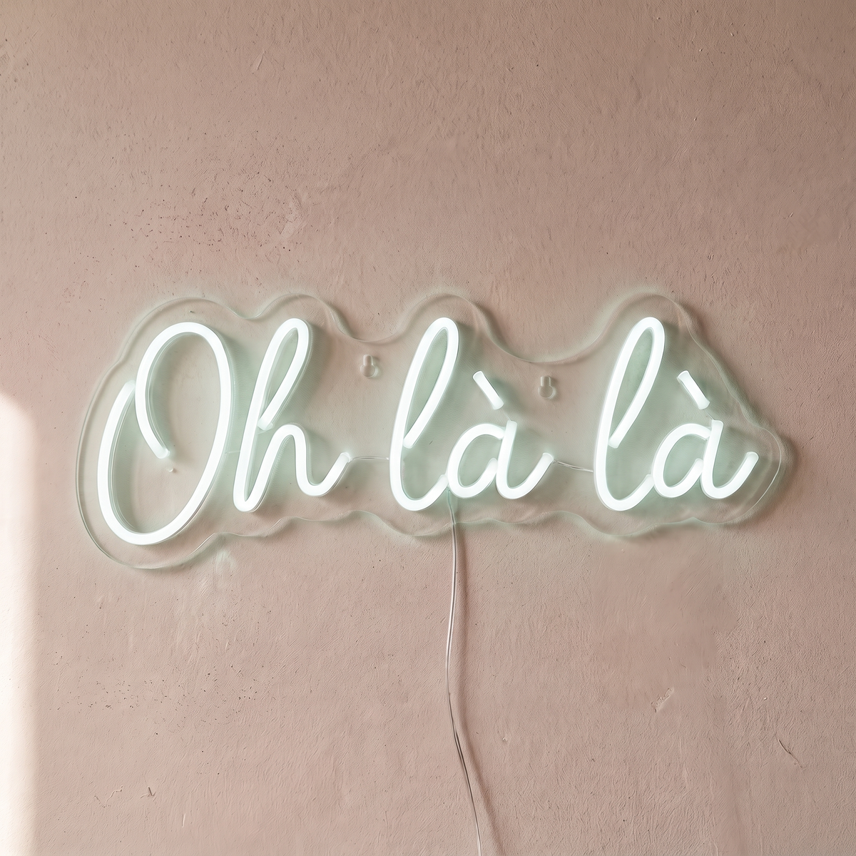 Néon mural « Oh là là » blanc froid, gros plan sur fond beige