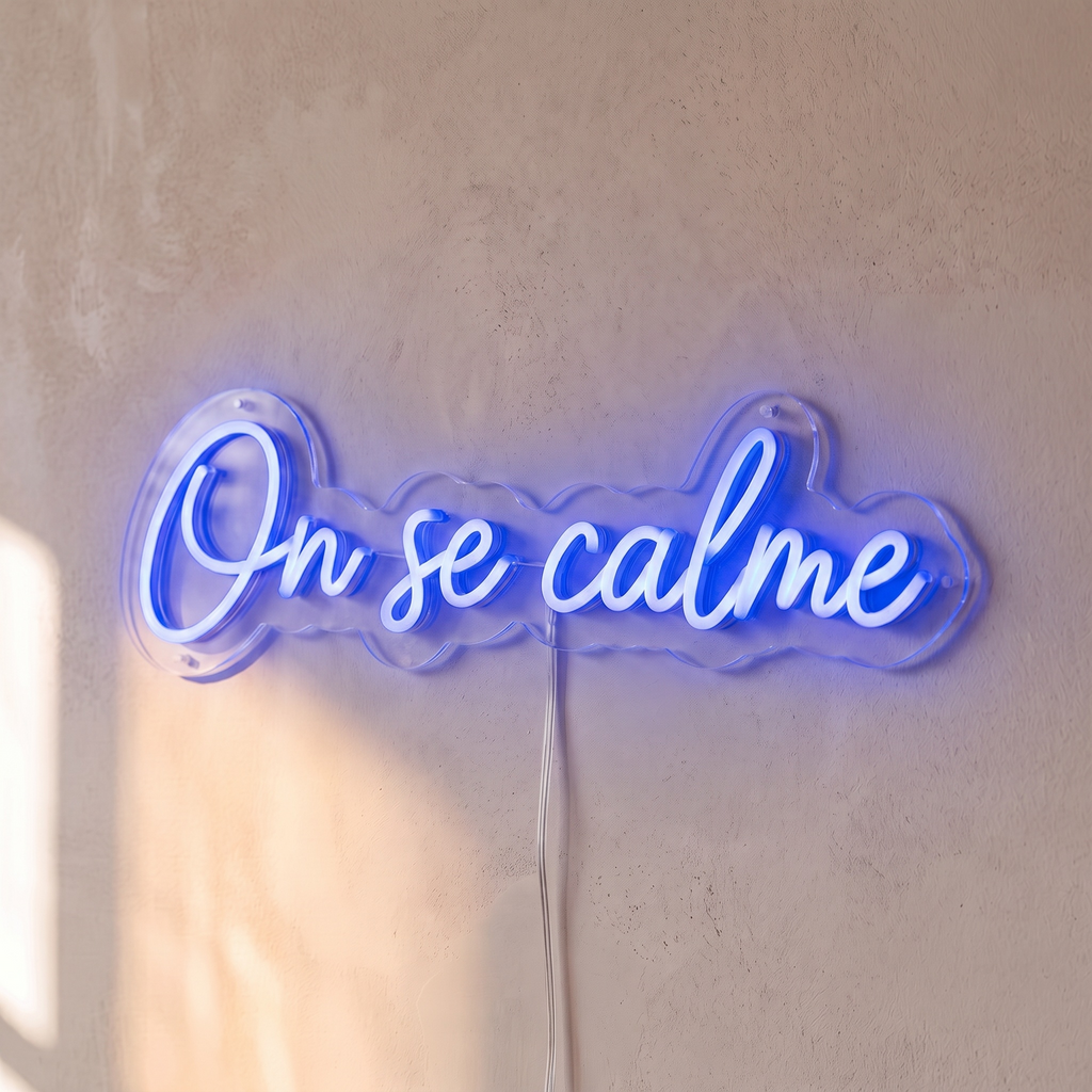 Néon mural « On se calme » bleu, gros plan sur fond beige