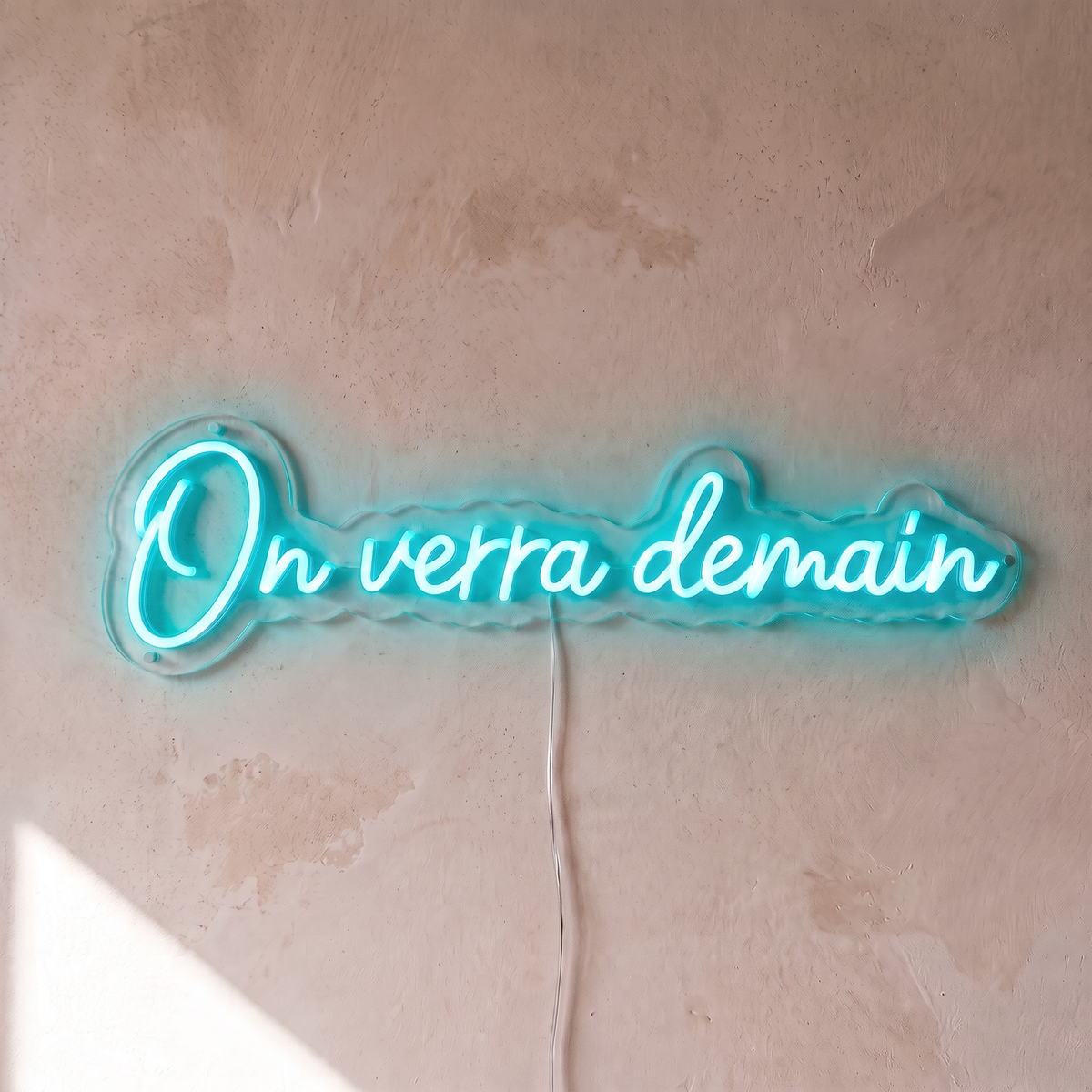 Néon mural « On verra demain » turquoise, gros plan sur fond beige