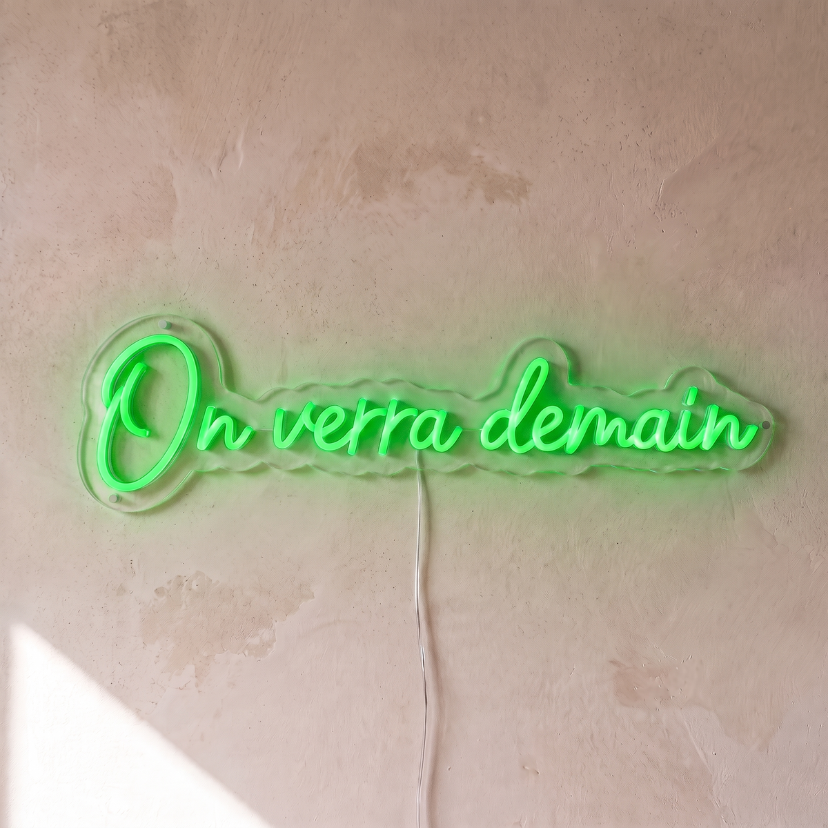 Néon mural « On verra demain » vert, gros plan sur fond beige