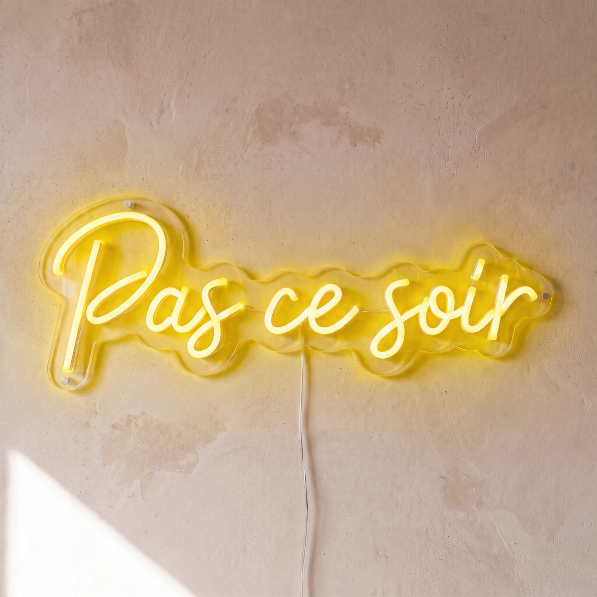 Néon mural « Pas ce soir » jaune, gros plan sur fond beige
