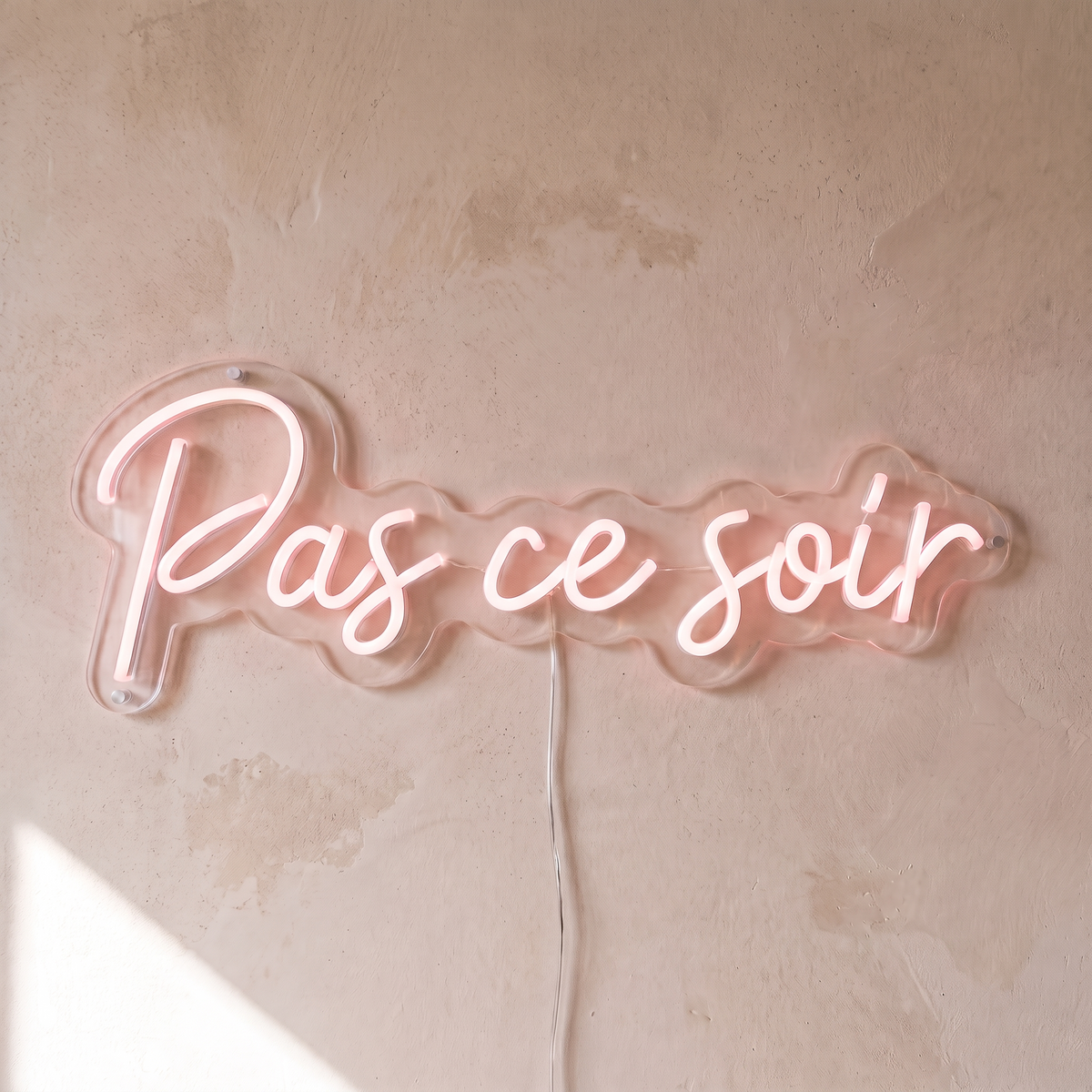 Néon mural « Pas ce soir » rose pâle, gros plan sur fond beige
