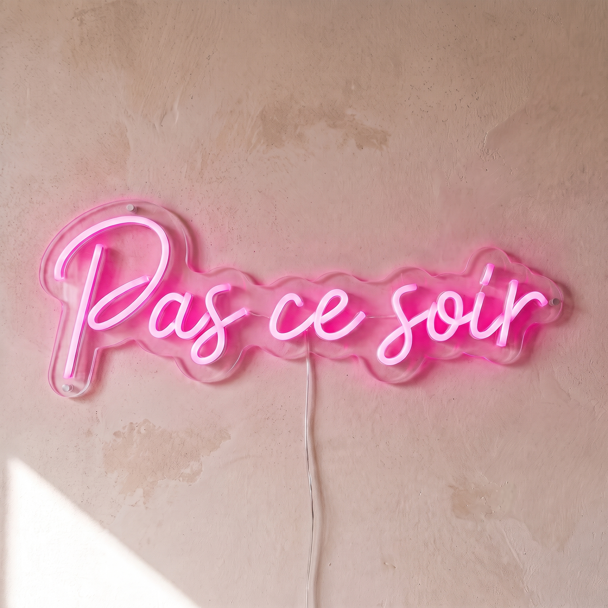 Néon mural « Pas ce soir » rose, gros plan sur fond beige