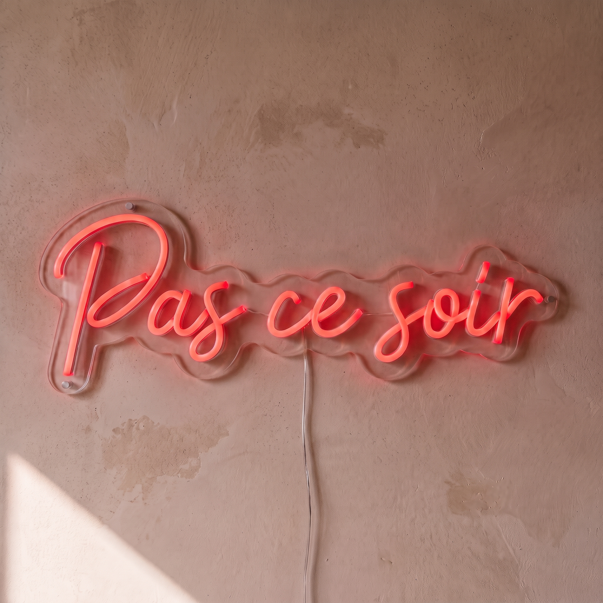 Néon mural « Pas ce soir » rouge, gros plan sur fond beige