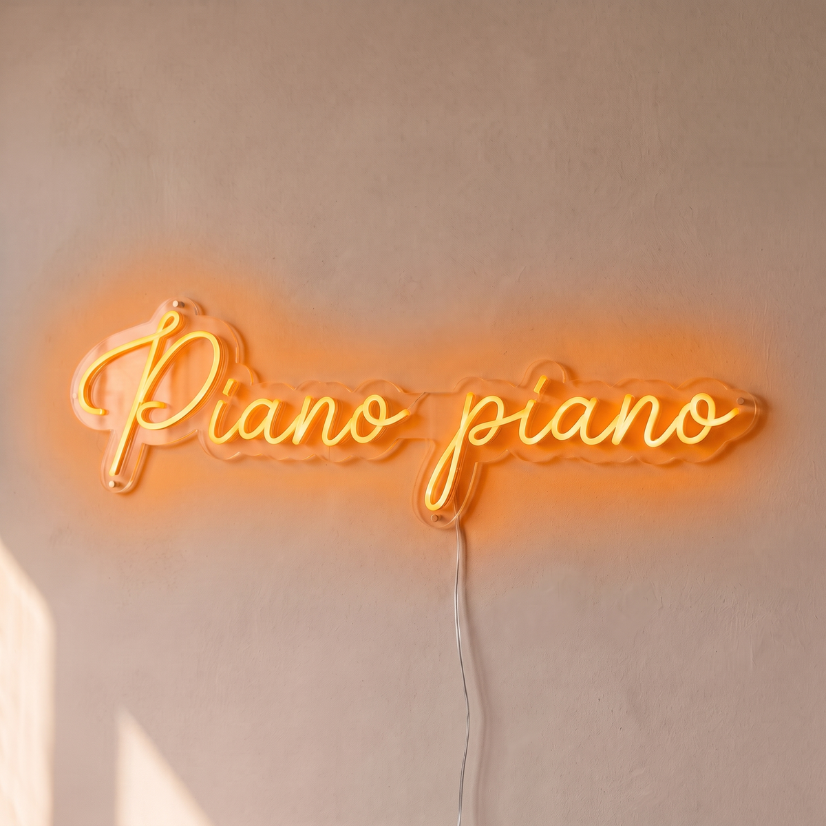 Néon mural « Piano piano » orange, gros plan sur fond beige
