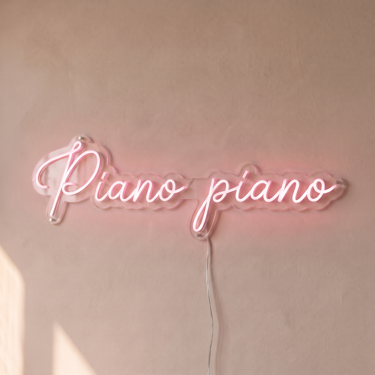 Néon mural « Piano piano » rose pâle, gros plan sur fond beige