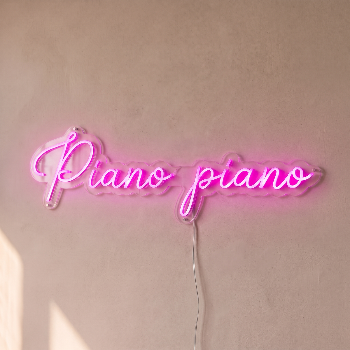 Néon mural « Piano piano » rose, gros plan sur fond beige