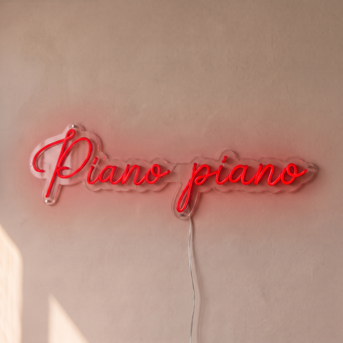 Néon mural « Piano piano » rouge, gros plan sur fond beige