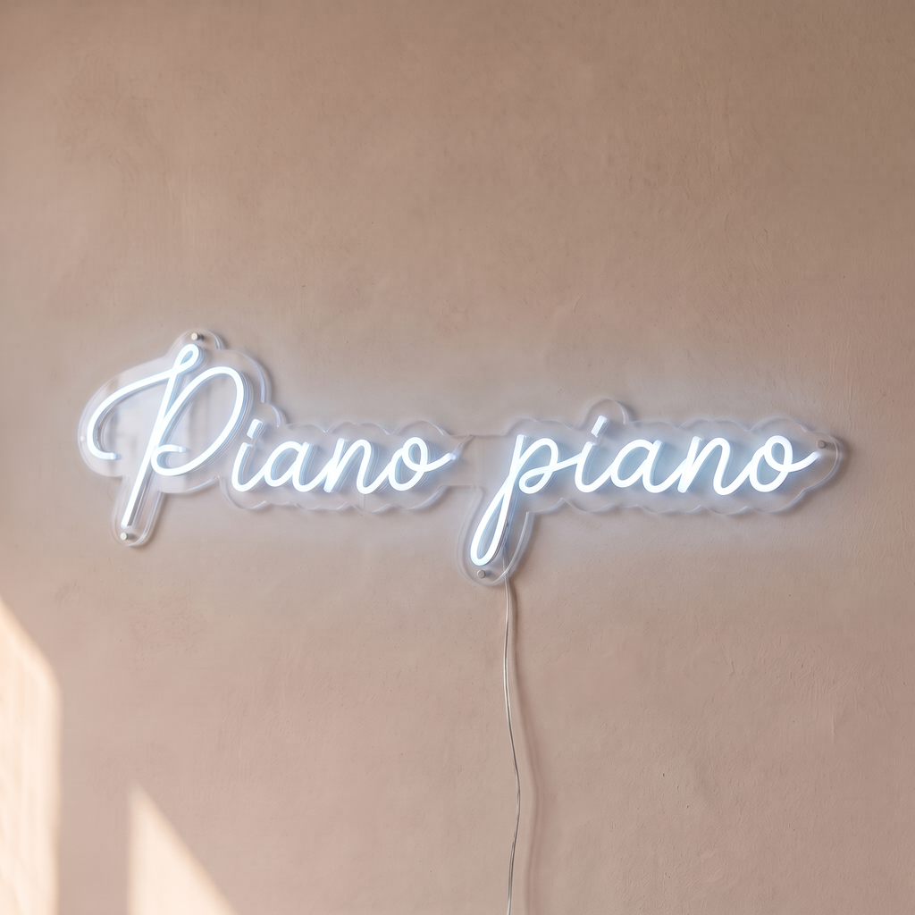 Néon mural « Piano piano » blanc froid, gros plan sur fond beige