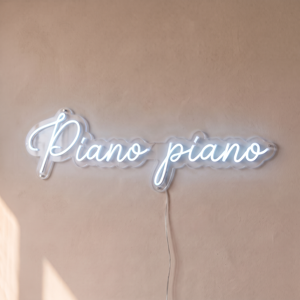 Néon mural « Piano piano » blanc froid, gros plan sur fond beige