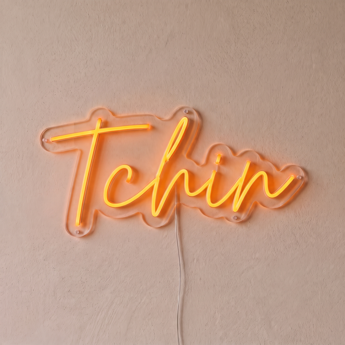 Néon mural « Tchin » orange, gros plan sur fond beige