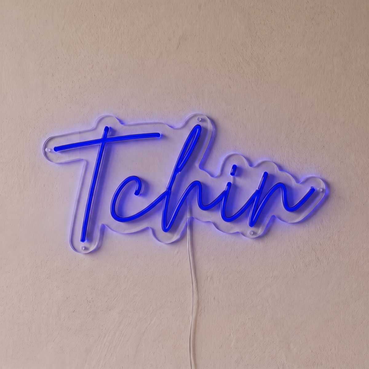 Néon mural « Tchin » bleu, gros plan sur fond beige