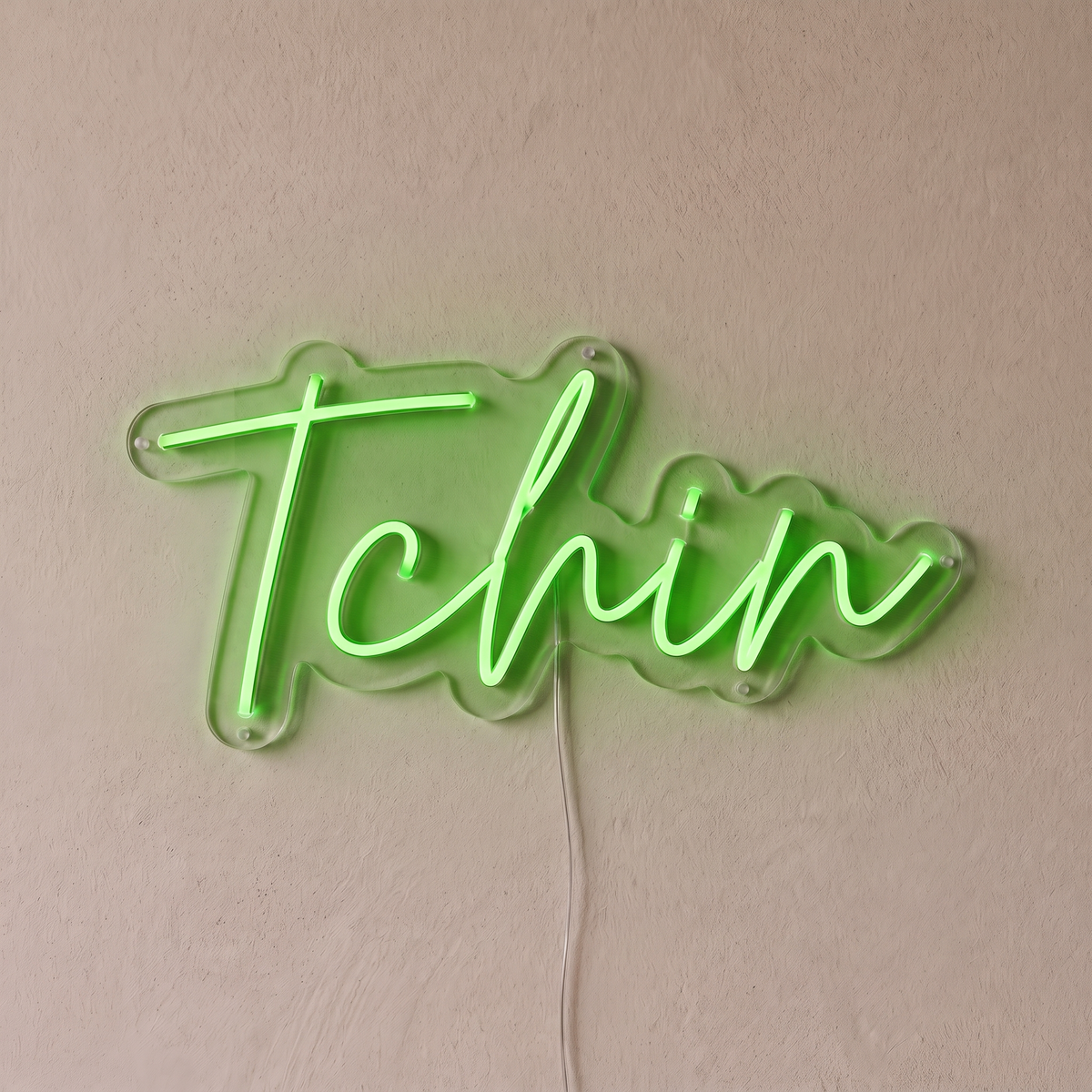 Néon mural « Tchin » vert, gros plan sur fond beige