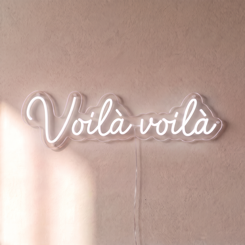 Néon mural « Voilà voilà » blanc, gros plan sur fond beige