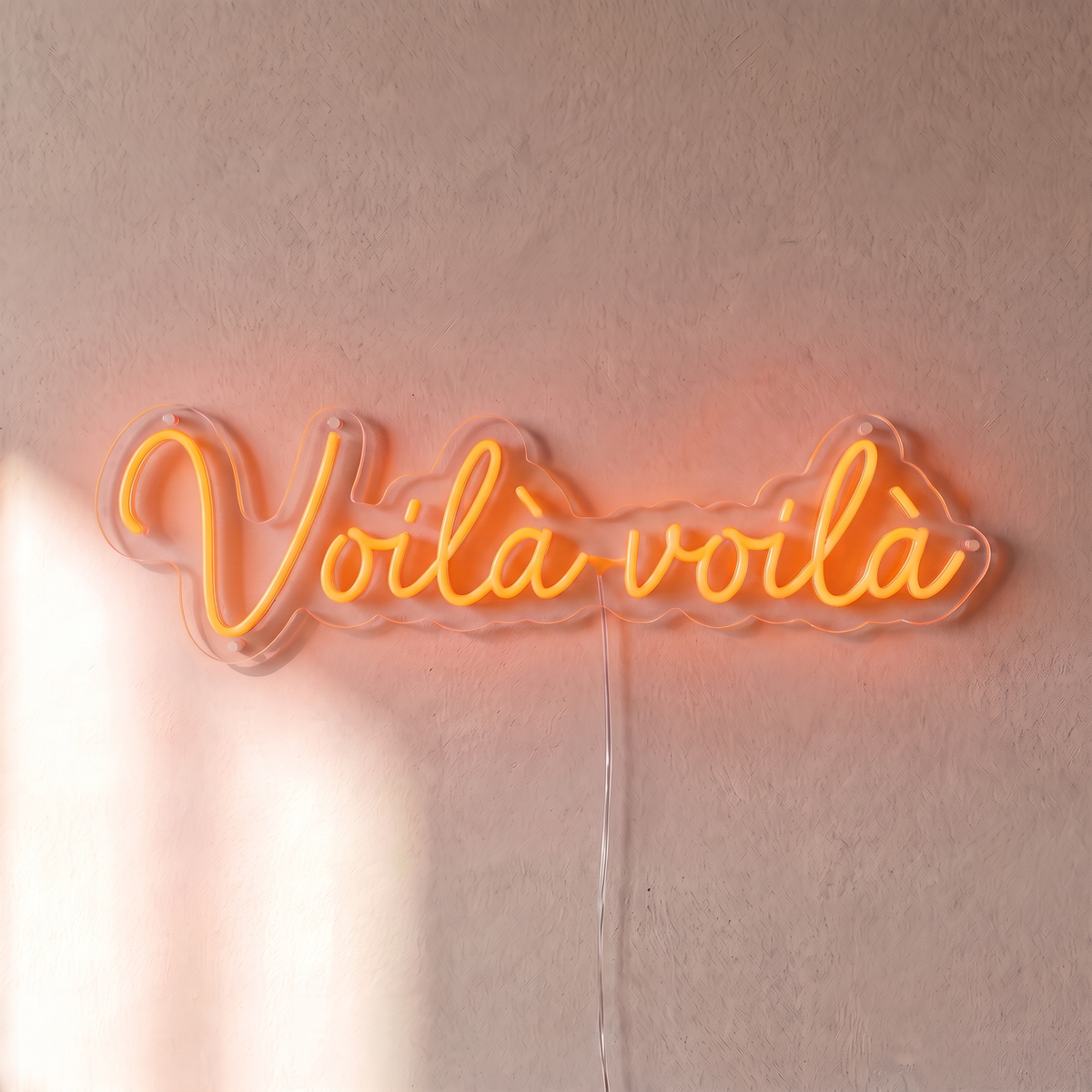 Néon mural « Voilà voilà » orange, gros plan sur fond beige