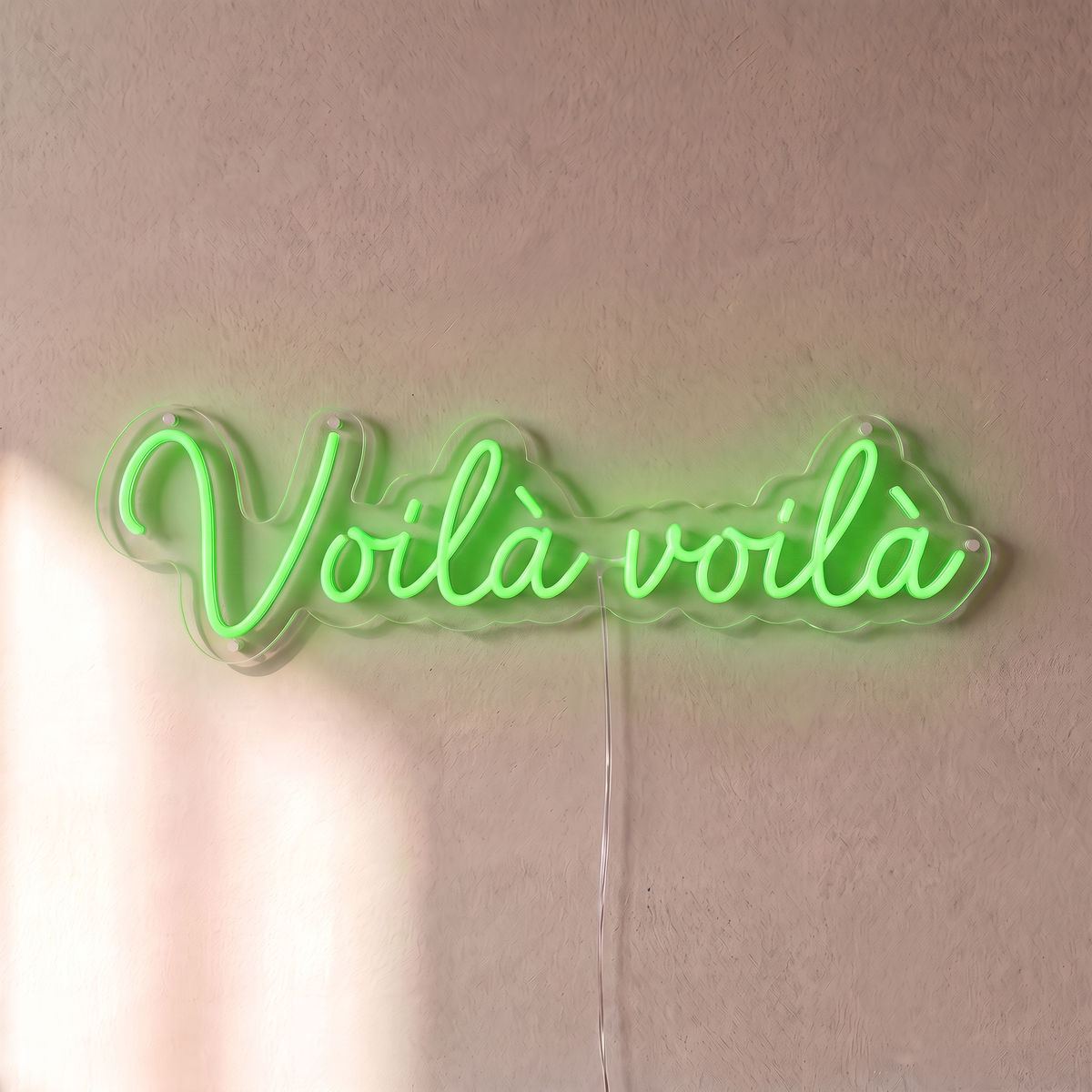 Néon mural « Voilà voilà » vert, gros plan sur fond beige